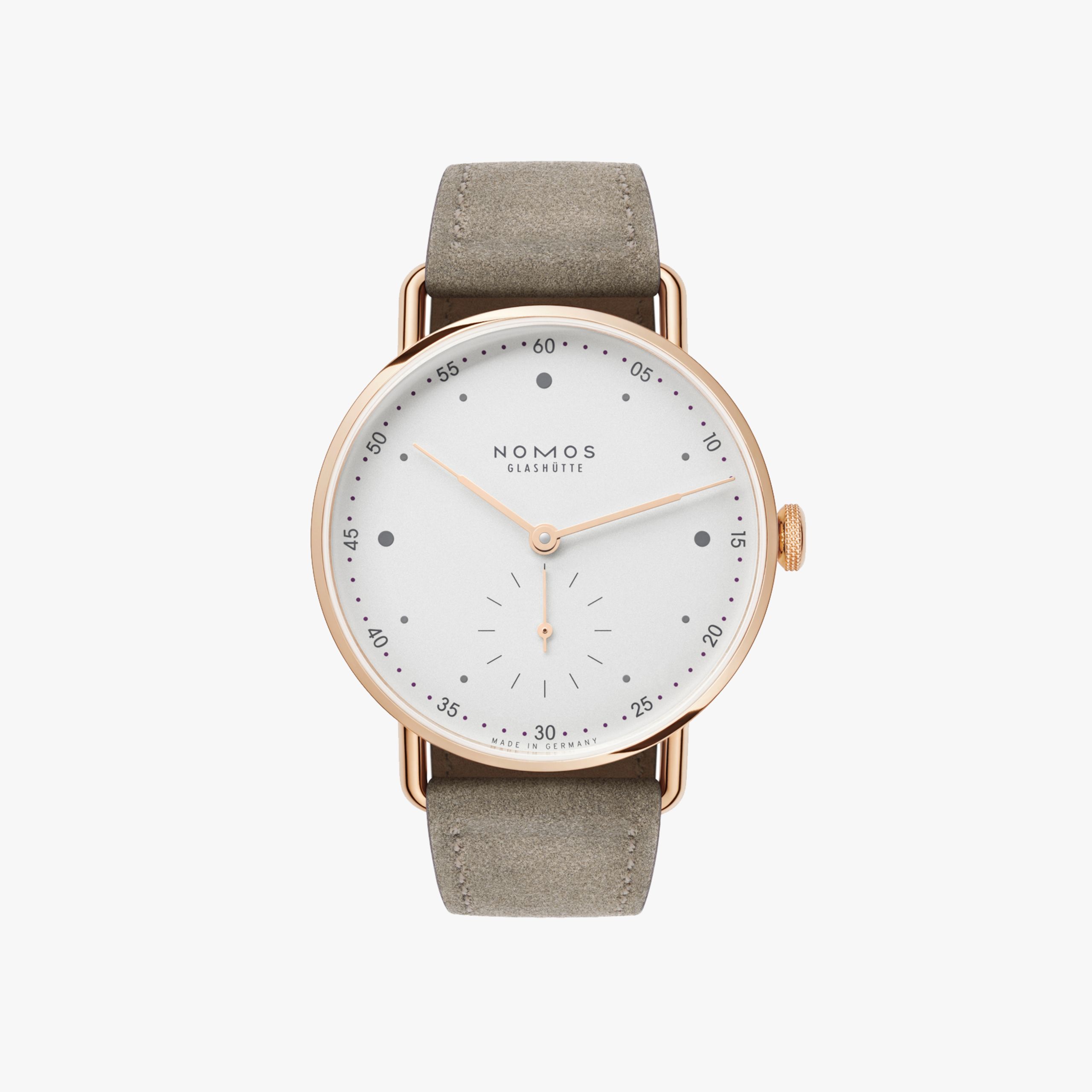 De Nomos Metro 1170 in roségoud heeft een minimalistisch design met een fluweelzachte wijzerplaat. De horlogekast is gemaakt van 18 krt goud en heeft een diameter van 33mm. De bruine suede band zorgt voor een luxe uitstraling. Draag dit horloge bij zowel formele als informele gelegenheden voor een stijlvolle uitstraling. Een tijdloos en elegant accessoire voor elke gelegenheid!
