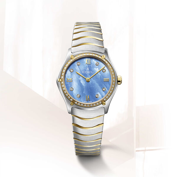 EBEL Sport Classic - 1216598 dames pols horloge. Edelstalen kast gecombineerd met 18 karaat geel goud. Ø 29 mm. Blauwe parelmoeren wijzerplaat met Romeinse cijfers en 8 diamanten ( 0,052 crt ). Ontspiegeld Saffier glas. Edelstalen Wave band met goud accenten en klap sluiting. Zwitsers quartz uurwerk. 5 ATM waterdicht.