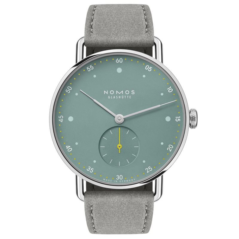 De Nomos 1124 Metro 33 is een elegant horloge met een minimalistisch design en hoogwaardige materialen. Het heeft een sage groene wijzerplaat, zilveren wijzers en een grijze suede band. Dit horloge past perfect om de pols en kan casual of formeel gedragen worden. Combineer het met een chique outfit voor een stijlvolle look. Laat dit prachtige horloge uw dagelijkse metgezel zijn!