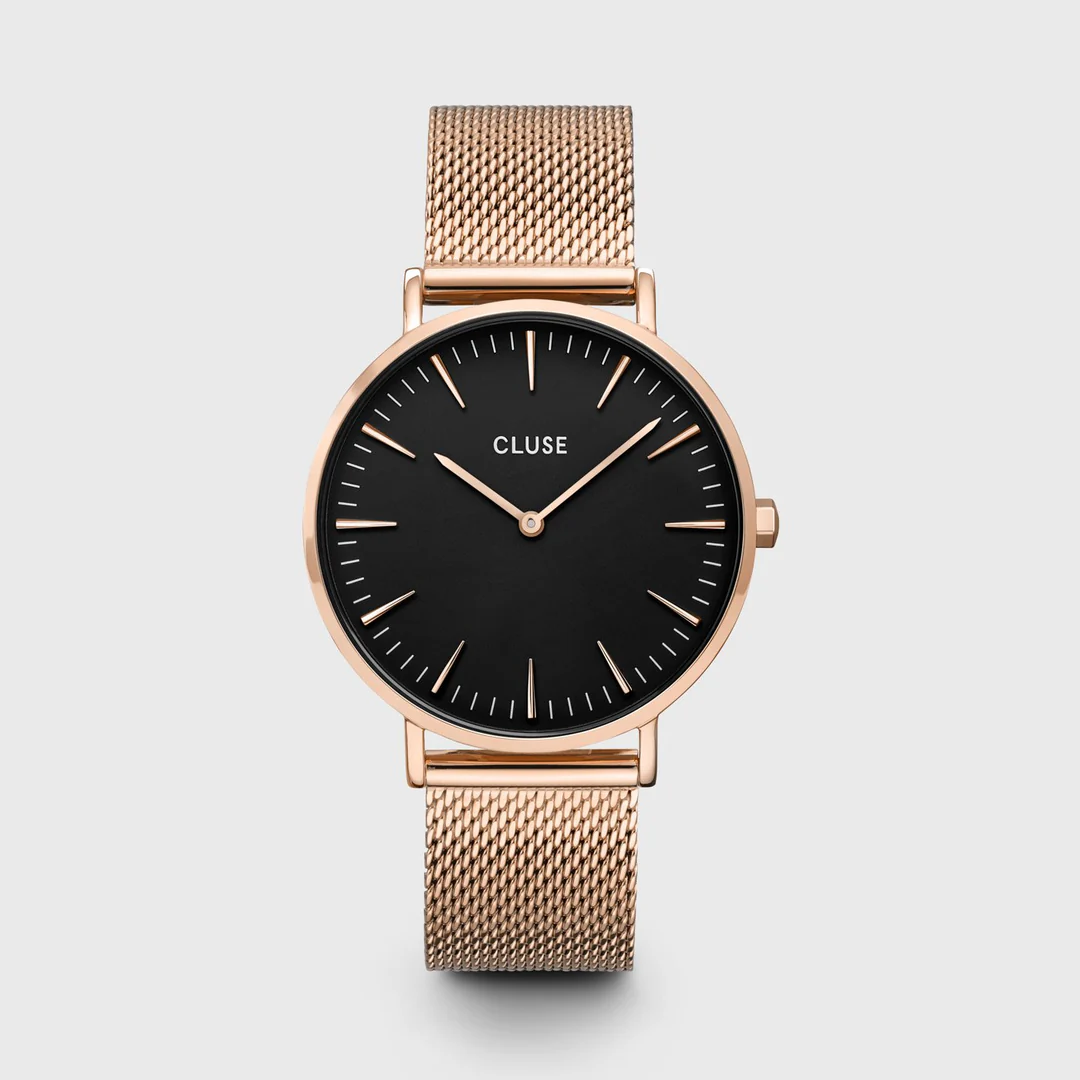 Roségoudkleurige elegantie. Inktzwarte romantiek. De gloed van champagne en de belofte van middernacht. Chic raffinement met een ondeugende ondertoon. Verpakt in een grijze kunstleren etui. Net zoals bij al onze horloges uit de Boho Chic-collectie kun je dit horloge gemakkelijk personaliseren met alle leren of mesh bandjes uit de Boho Chic- of La Roche-lijn.