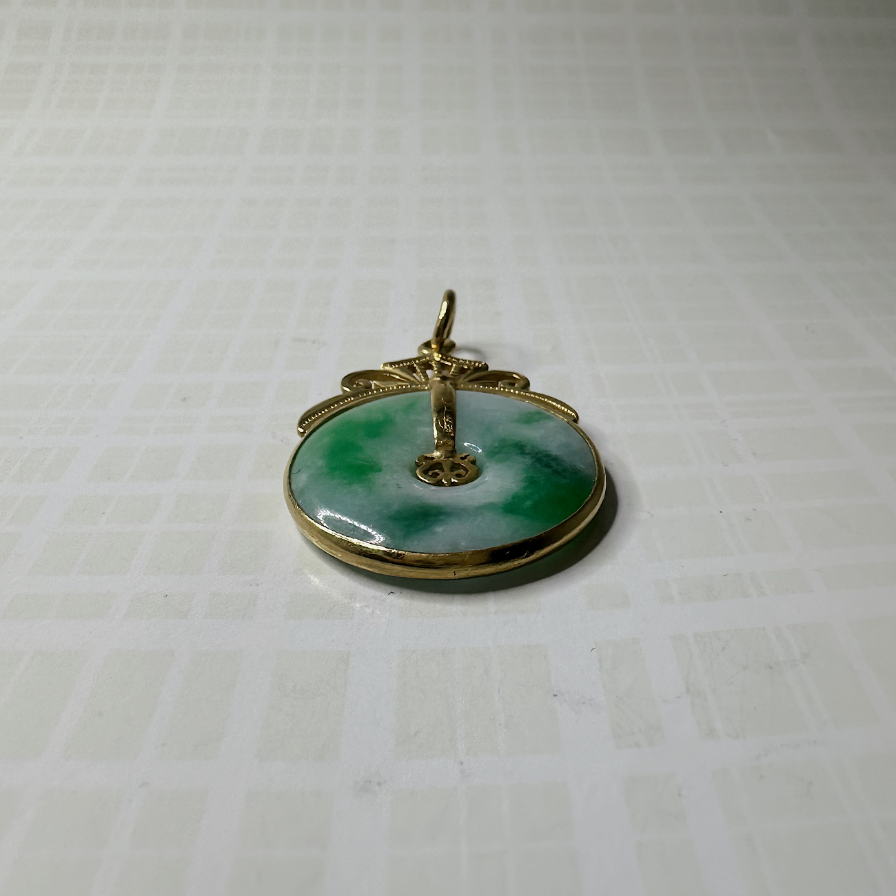 Deze prachtige vintage hanger is gemaakt van 24 karaat geelgoud. De hanger is uitgevoerd met een opvallende, donutgevormde jade. 
