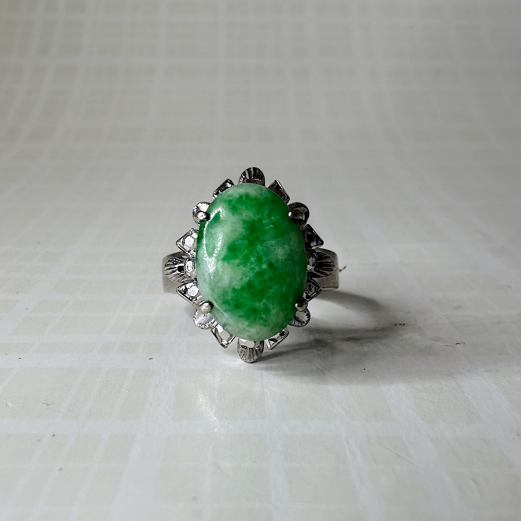 Deze prachtige vintage ring is gemaakt van 8 karaat witgoud. De ring is uitgevoerd met een opvallende jade en met daaromheen markasiet. De beschikbare maat is 16,5.