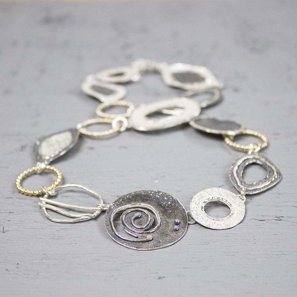 Collier uit de Touch of Gold-collectie van Jéh Jewels, gemaakt van 925 sterling zilver met hoogglans, geoxideerd zilver en een laagje Gold Filled goud. Dit collier bestaat uit verschillende organische vormen, wisselend van materiaal. Dit collier doet ons denken aan een dagje relaxen op het strand, stylish en bohemian.
