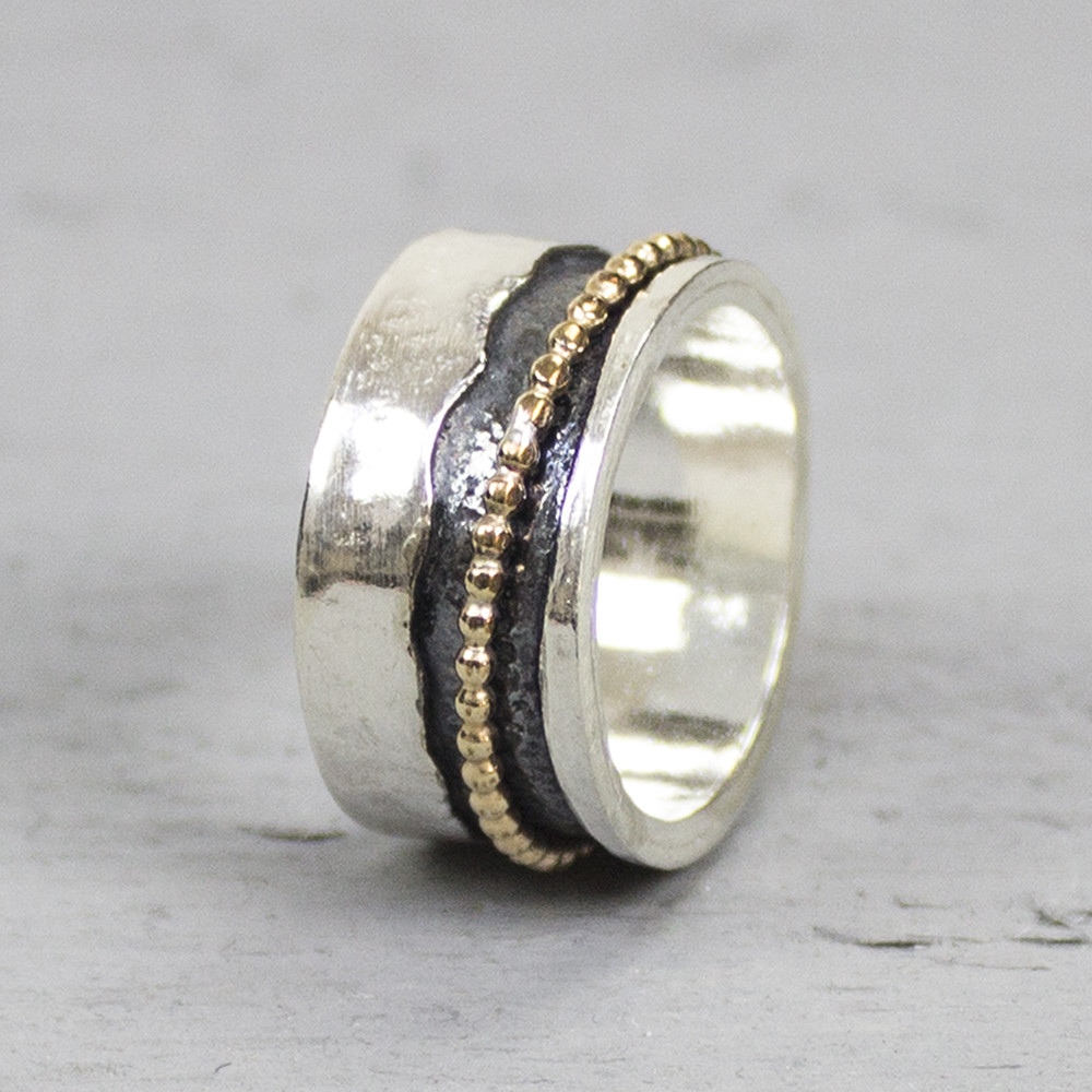Bijzondere ring gemaakt van (geoxideerd) 925 sterling zilver en gold filled. De ring in het midden van de ring kan bewegen dit zorgt voor een speels effect. Onder de ring is gebruik gemaakt van geoxideerd zilver. Doordat de ring speels beweegt is het mogelijk dat de geoxideerde laag na verloop van tijd vervaagd. De glans van 925 sterling zilver maakt het een gewild edelmetaal voor de vervaardiging van sieraden. Het bestaat uit 925% puur zilver en 75% koper. Puur zilver is een zacht en buigzaam materiaal het koper in 925 sterling zilver zorgt voor de stevigheid. De sieraden van Jeh Jewels zijn nikkel vrij. Gold filled komt uit Amerika en wordt daar al langer gebruikt voor de vervaardiging van sieraden met een "touch of gold" voor een betaalbare prijs. Het gold filled blijft op kleur is slijtvast en de 14karaats goudlaag is dik genoeg om lang te kunnen genieten van de warme uitstraling van goud. Gold filled wordt veelal ook goed verdragen door mensen die allergisch zijn voor andere metalen dan goud.