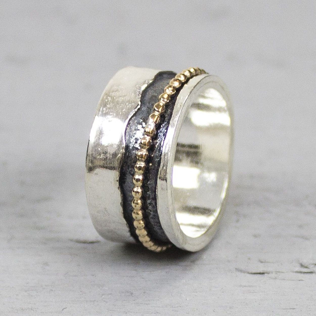 Bijzondere ring gemaakt van (geoxideerd) 925 sterling zilver en gold filled. De ring in het midden van de ring kan bewegen, dit zorgt voor een speels effect. Onder de ring is gebruik gemaakt van geoxideerd zilver. Doordat de ring speels beweegt, is het mogelijk dat de geoxideerde laag na verloop van tijd vervaagd.