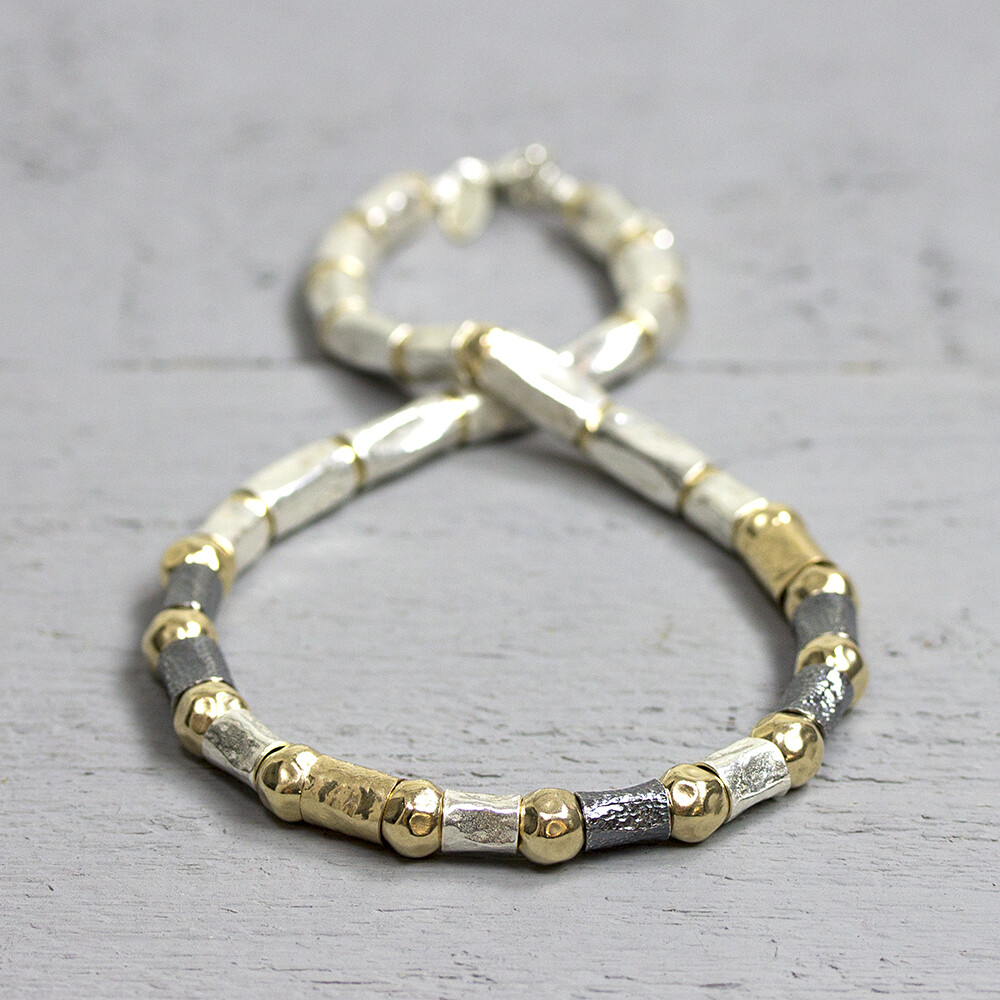 Collier gemaakt van 925 sterling zilver, geoxideerd zilver en goldfilled. Het collier bestaat uit verschillende grootte buisjes en hamerslag balletjes. Het collier is erg soepel waardoor hij mooi valt in de hals. De glans van 925 sterling zilver maakt het een gewild edelmetaal voor de vervaardiging van sieraden. Het bestaat uit 92,5% puur zilver en 7,5% koper. Puur zilver is een zacht en buigzaam materiaal, het koper in 925 sterling zilver zorgt voor de stevigheid. De sieraden van Jeh Jewels zijn nikkel vrij. Op dit sieraad is gebruik gemaakt van geoxideerd zilver, dit is een oppervlakte bewerking. Het is mogelijk dat de geoxideerde laag na verloop van tijd door slijtage gaat vervagen. Gold filled komt uit Amerika en wordt daar al langer gebruikt voor de vervaardiging van sieraden met een "touch of gold" voor een betaalbare prijs. Het gold filled blijft op kleur, is slijtvast en de goudlaag is dik genoeg om lang te kunnen genieten van de warme uitstraling van goud. Gold filled wordt veelal ook goed verdragen door mensen die allergisch zijn voor andere metalen dan goud.