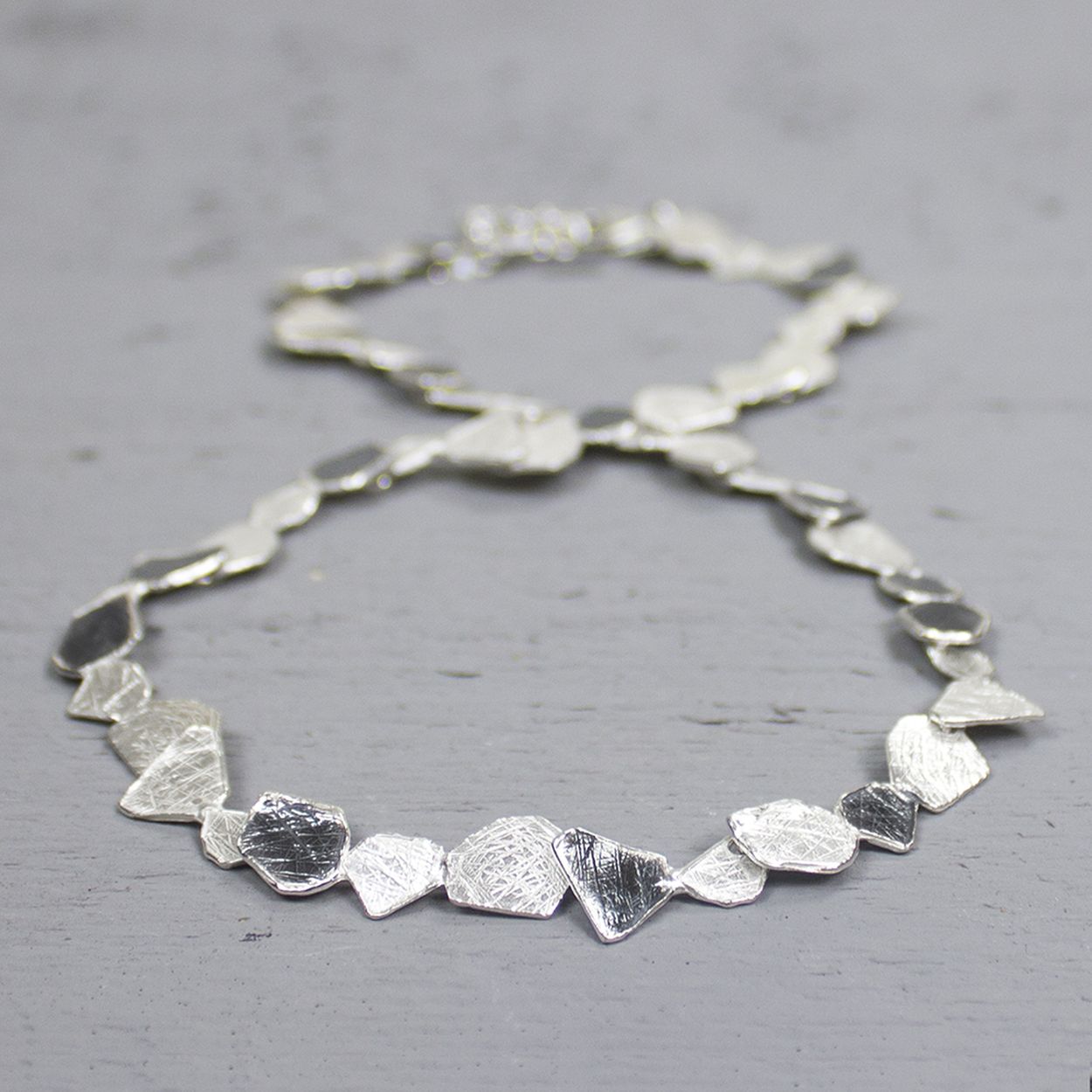 Dit collier is gemaakt van 925 sterling zilver. Enkele schakels zijn geoxideerd wat zorgt voor een mooi zwart-wit patroon. De schakels zelf hebben een leuke en afwisselende organische vormen. 