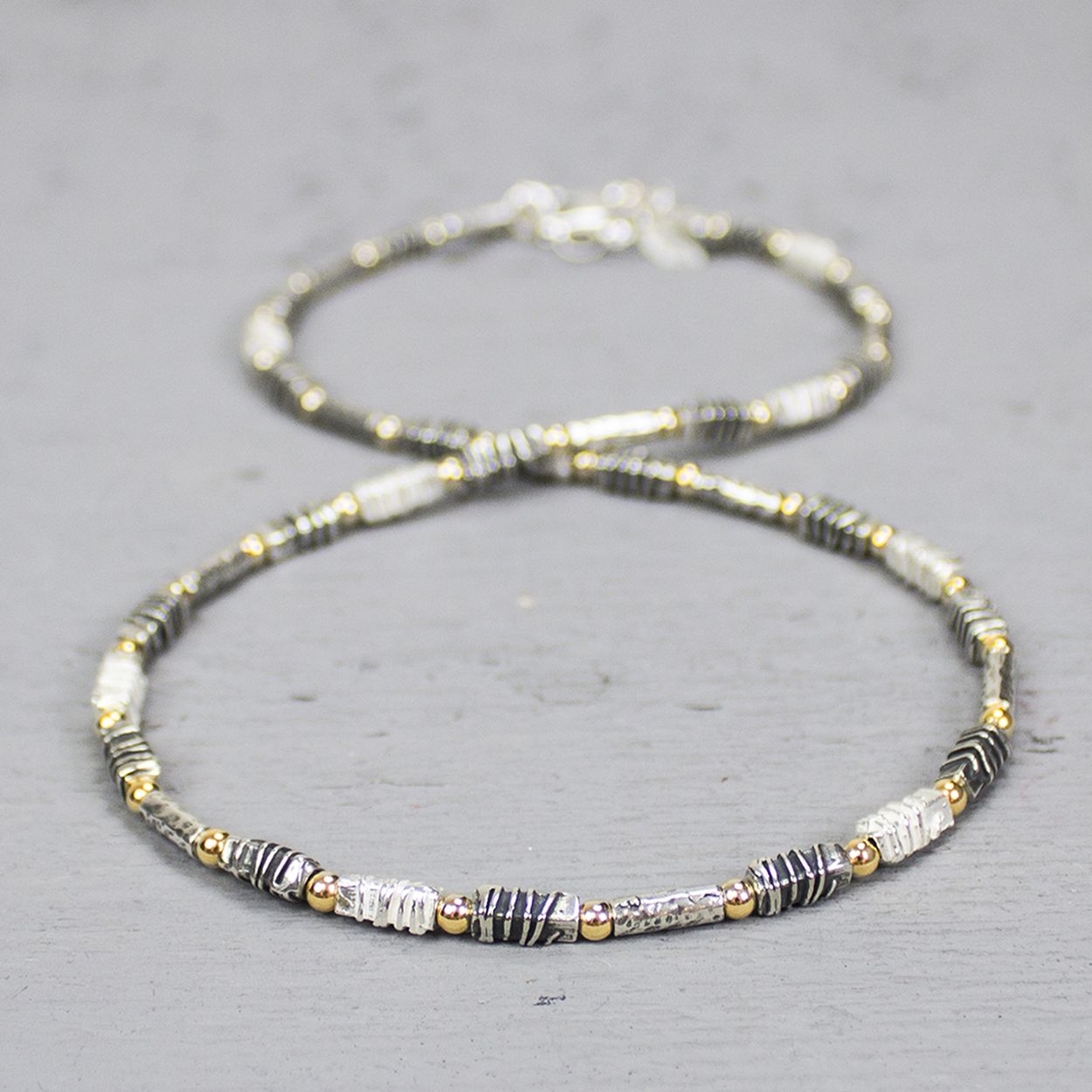 Collier uit de Touch of Gold-collectie van Jéh Jewels, gemaakt van 925 sterling zilver, geoxideerd zilver en Goldfilled. De schakels hebben allemaal een unieke stuctuur, wat dit collier zo bijzonder maakt. Combineer dit collier met het bijpassende armband.  