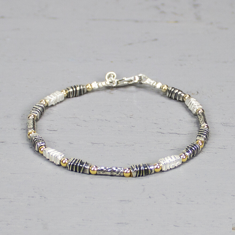 Armband uit de Touch of Gold-collectie van Jéh Jewels, gemaakt van 925 sterling zilver, geoxideerd zilver en gold filled. De schakels hebben allemaal een unieke stuctuur, wat deze armband zo bijzonder maakt. Deze armband is te combineren met een bijpassend collier.  