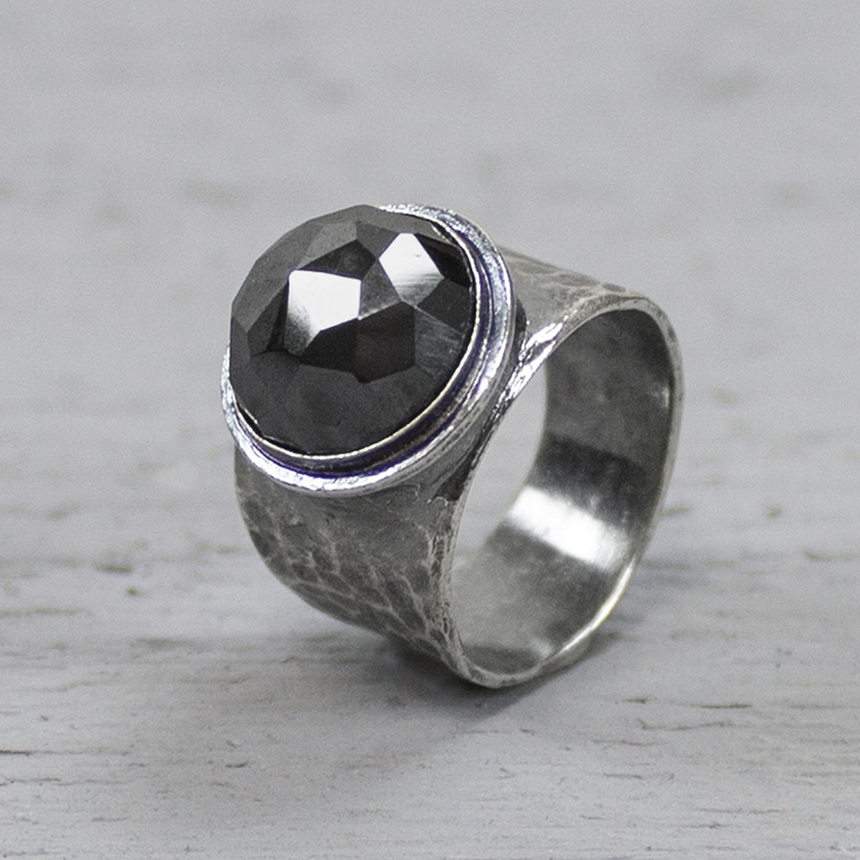 Ring uit de Silver-collectie van Jéh Jewels, gemaakt van 925 sterling zilver met gefacetteerde hematiet. De ring is bewerkt met hamerslag wat zorgt voor een mooie structuur. Hematiet werkt aardend, beschermend en harmoniserend. De steen geeft zelfvertrouwen, vergroot het zelfrespect en de overlevingsdrang en versterkt de wilskracht.
