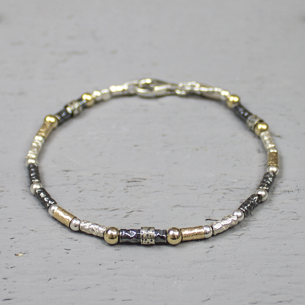 Armband gemaakt van 925 sterling zilver geoxideerd zilver en goldfilled. Deze armband is een uitbreiding op de 17710 heeft afwisselend de eerder genoemde metaalsoorten en is bewerkt met een lichte hamerslag. Over een aantal schakels zit een zilver bandje dit creeert een speels effect. Het is bekend dat geoxideerd zilver na verloop van tijd vervaagd. De glans van 925 sterling zilver maakt het een gewild edelmetaal voor de vervaardiging van sieraden. Het bestaat uit 925% puur zilver en 75% koper. Puur zilver is een zacht en buigzaam materiaal het koper in 925 sterling zilver zorgt voor de stevigheid. De sieraden van Jeh Jewels zijn nikkel vrij. Gold filled komt uit Amerika en wordt daar al langer gebruikt voor de vervaardiging van sieraden met een "touch of gold" voor een betaalbare prijs. Het gold filled blijft op kleur is slijtvast en de goudlaag is dik genoeg om lang te kunnen genieten van de warme uitstraling van goud. Gold filled wordt veelal ook goed verdragen door mensen die allergisch zijn voor andere metalen dan goud.
