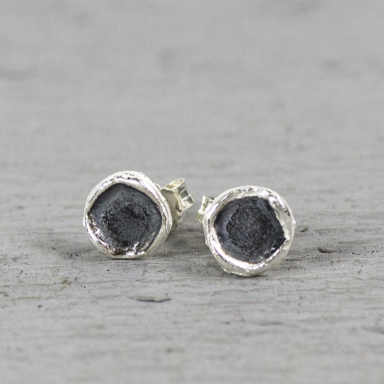 Oorknopjes gemaakt van 925 sterling zilver en geoxideerd zilver de oorknop heeft een ronde organische vorm. De randen van de oorstekers staan omhoog voor meer diepte.