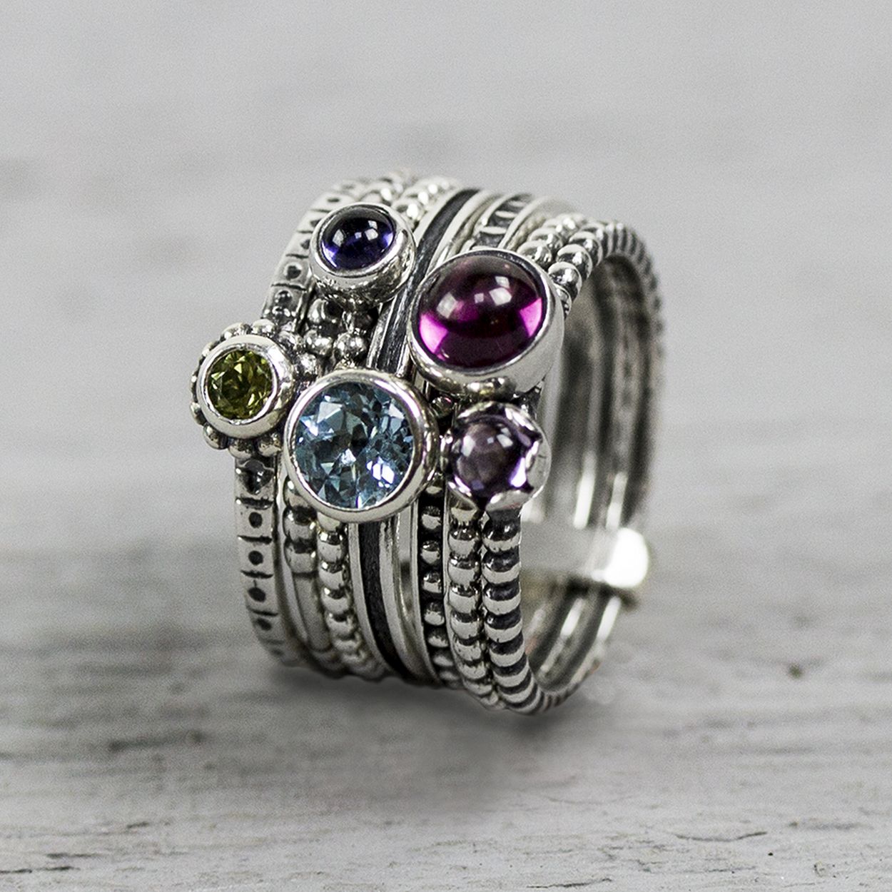 Ring gemaakt van 925 sterling zilver met vijf gefaceteerde kleurrijke stenen. Op deze ring zit een blauwe Topaas, Peridot, Rodoliet, Amethist en Ioliet.