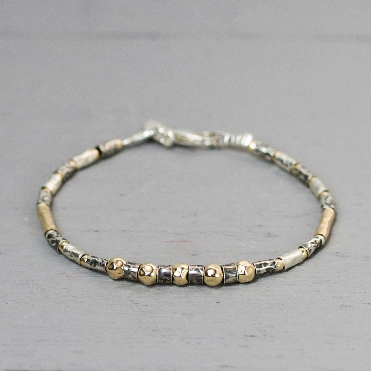Een armband in de serie 'buisjes" armbanden. Deze armband is gemaakt van 925 sterling zilver, geoxideerd zilver en Goldfilled.