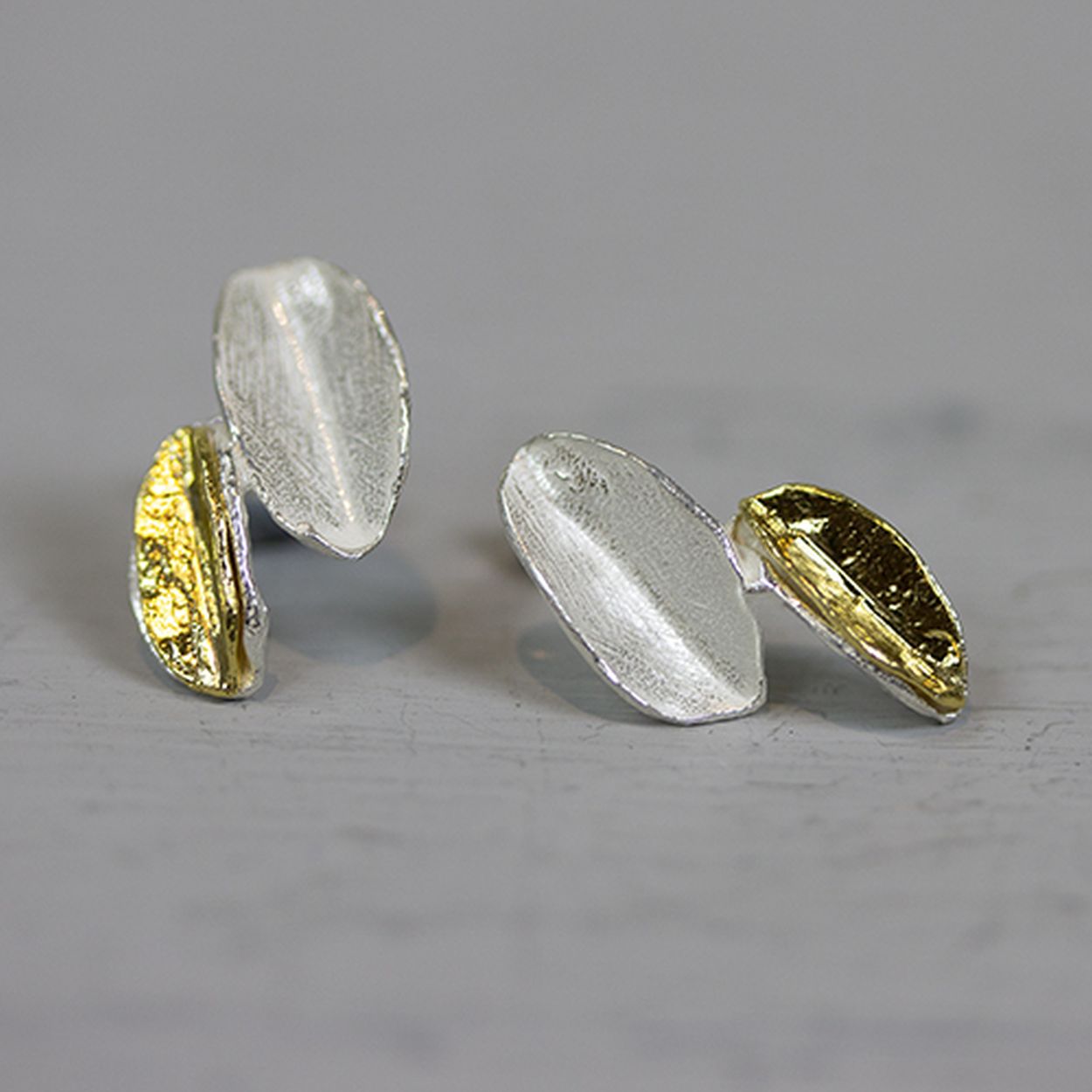 Oorbel gemaakt van 925 sterling zilver en verguld zilver in de vorm van twee bladeren.
