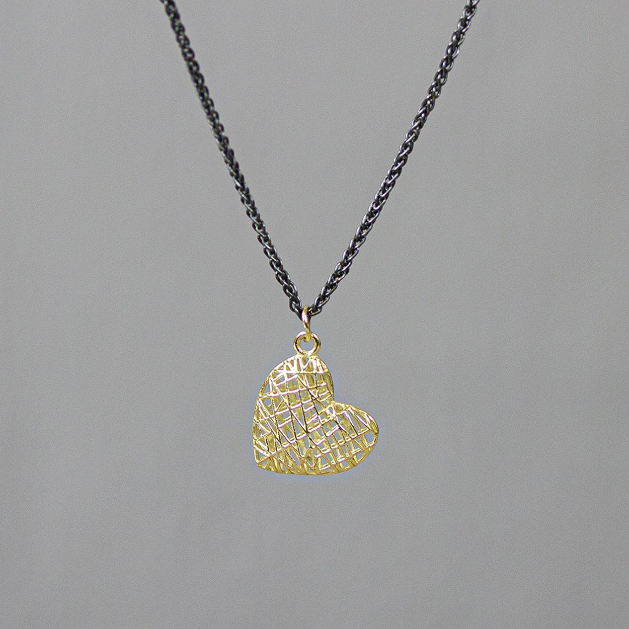 Het schakel collier is gemaakt van 925 geoxideerd sterling zilver met daaraan een hanger in de vorm van een hart van 14 karaat. De hanger is gemaakt met behulp van een 3D printer. Hierdoor is de hanger mooi bol en kun je erdoorheen kijken.