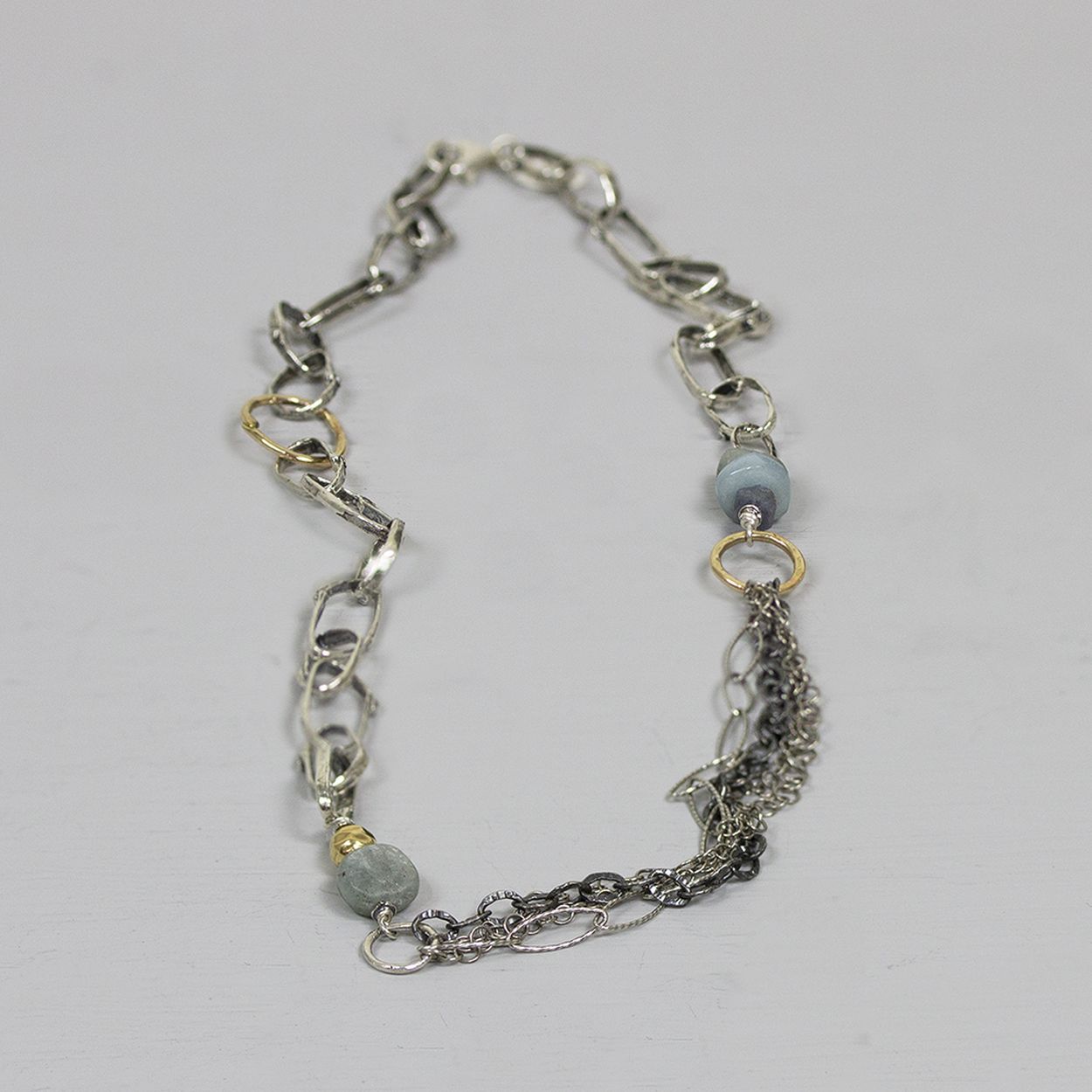 Collier van het Nederlandse merk Jeh Jewels gemaakt van 925 (geoxideerd) sterling zilver met accenten goldfilled. Naast de goldfilled delen, zijn er ook verschillende blauwe edelstenen in dit collier verwerkt (Kyaniet, aquamarijn, ruwe Saffier). De glans van 925 sterling zilver maakt het een gewild edelmetaal voor de vervaardiging van sieraden. Het bestaat uit 92,5% puur zilver en 7,5% koper. Puur zilver is een zacht en buigzaam materiaal, het koper in 925 sterling zilver zorgt voor de stevigheid. De sieraden van Jéh Jewels zijn nikkel vrij. Op dit sieraad is gebruik gemaakt van geoxideerd zilver, dit is een oppervlakte bewerking. Het is mogelijk dat de geoxideerde laag na verloop van tijd door slijtage zal vervagen. Goldfilled komt uit Amerika en wordt daar al langer gebruikt voor de vervaardiging van sieraden met een "touch of gold" voor een betaalbare prijs. Het goldfilled blijft op kleur, is slijtvast en de goudlaag is dik genoeg om lang te kunnen genieten van de warme uitstraling van goud. Goldfilled wordt veelal ook goed verdragen door mensen die allergisch zijn voor andere metalen dan goud. Bij Jéh Jewels werken wij met echte edelstenen, dit zijn natuurlijke producten waardoor niet iedere steen hetzelfde is. Ieder sieraad is hierbij dus uniek. De kleur en structuur van de steen kan afwijken van de foto op de website.