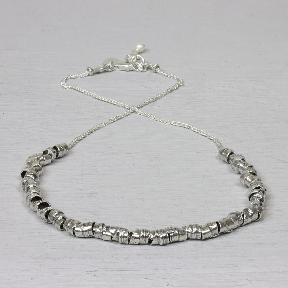 Collier gemaakt van 925 (oxy shiny) sterling zilver met daaraan speelse zilveren buisjes. Oxy shiny is zilver wat geoxideerd is en daana weer gepoleisd. Hierdoos blijft het zilver kleurvast. De glans van 925 sterling zilver maakt het een gewild edelmetaal voor de vervaardiging van sieraden. Het bestaat uit 92,5% puur zilver en 7,5% koper. Puur zilver is een zacht en buigzaam materiaal, het koper in 925 sterling zilver zorgt voor de stevigheid. De sieraden van Jeh Jewels zijn nikkel vrij. Op dit sieraad is gebruik gemaakt van geoxideerd zilver, dit is een oppervlakte bewerking. Het is mogelijk dat de geoxideerde laag na verloop van tijd door slijtage gaat vervagen.