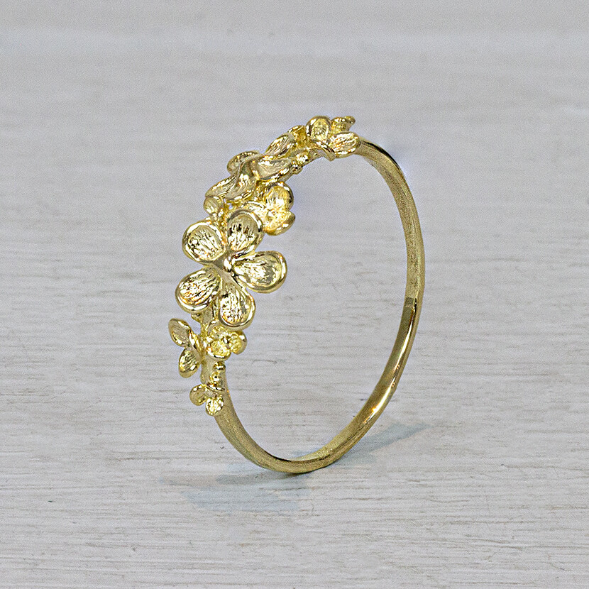 Ring uit de goud collectie van Jeh Jewels, gemaakt van 14 karaat goud. Op de bovenkant van de ring ligt een sierlijk bloembed, net bloesem! De gouden sieradenlijn van Jéh is gemaakt van 14 karaats goud. Dit karaatgehalte wordt in Nederland het meest gebruikt, vanwege de hardheid en de kleur. Puur goud is te zacht om draagbare sieraden van te maken, daarom worden er bij metalen gebruikt. Vaak wordt er zilver en koper gebruikt zodat je kunt blijven spreken van 'edele metalen'. Bij 14 karaat goud zijn er van de 1000 delen, 585 delen puur goud. De overige 415 delen bestaan dus uit de overige metalen. Prijswijzigingen voorbehouden!