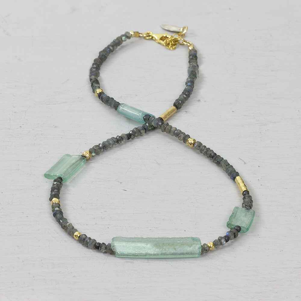 Collier Goldfilled gemaakt met Romeins Glas en Labradoriet. Een prachtig collier met een mooi verhaal. Het is qua uniekheid net een edelsteen, maar deze sieraden zijn gemaakt met Romeins Glas. De romeinen maakten dit 2000 jaar geleden al, met dezelfde reden als wij nu hebben voor glas! In de voorjaarscollectie is er nu een lijn sieraden in combinatie met dit glas. De unieke uitstraling en ambachtelijke look paste 32 jaar geleden als perfect in onze collectie. Bij Jeh Jewels zijn wij nog altijd gek op dit eeuwenoude glas en wij hopen jullie nu ook. Roman Glass by J&eacute;h how timeless do you want it to be.