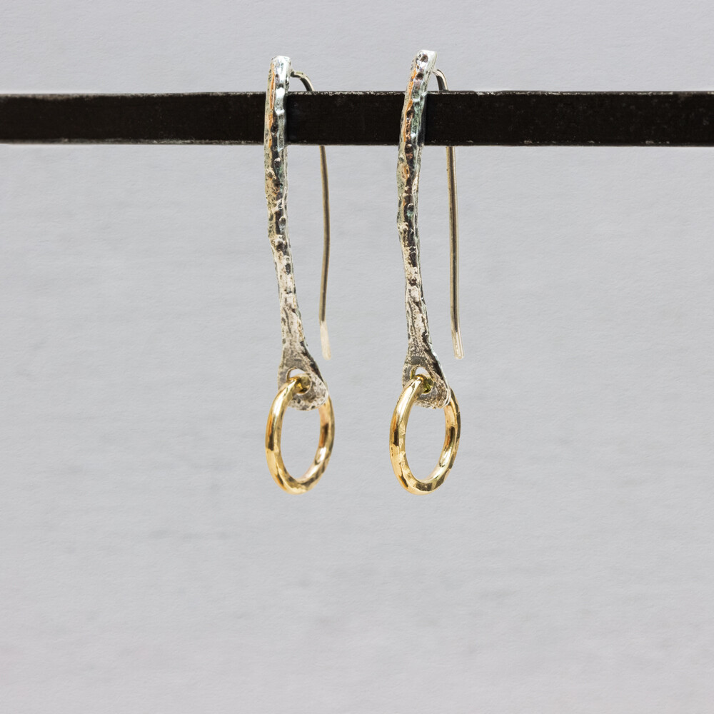 Oorhangers gemaakt van 925 shiny geoxideerd sterling zilver met onderaan een cirkel van Goldfilled. Deze oorbellen zijn een tikkeltje klassiek maar door de bewegende cirkel ook super speels. Combineer ze met een collier of een armband uit onze touch of gold collectie.