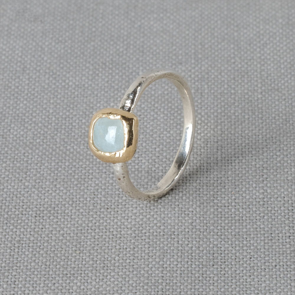 Ring gemaakt van 925 sterling zilver in combinatie met een 9 karaat vierkantje en de edelsteen Aquamarijn. Lees alles over deze edelsteen via onderstaande button. Deze ring is perfect te combineren met de andere Mix & Match ringen uit onze collectie! De afmeting van het vierkantje op de ring is 0,7 x 0,7 cm.