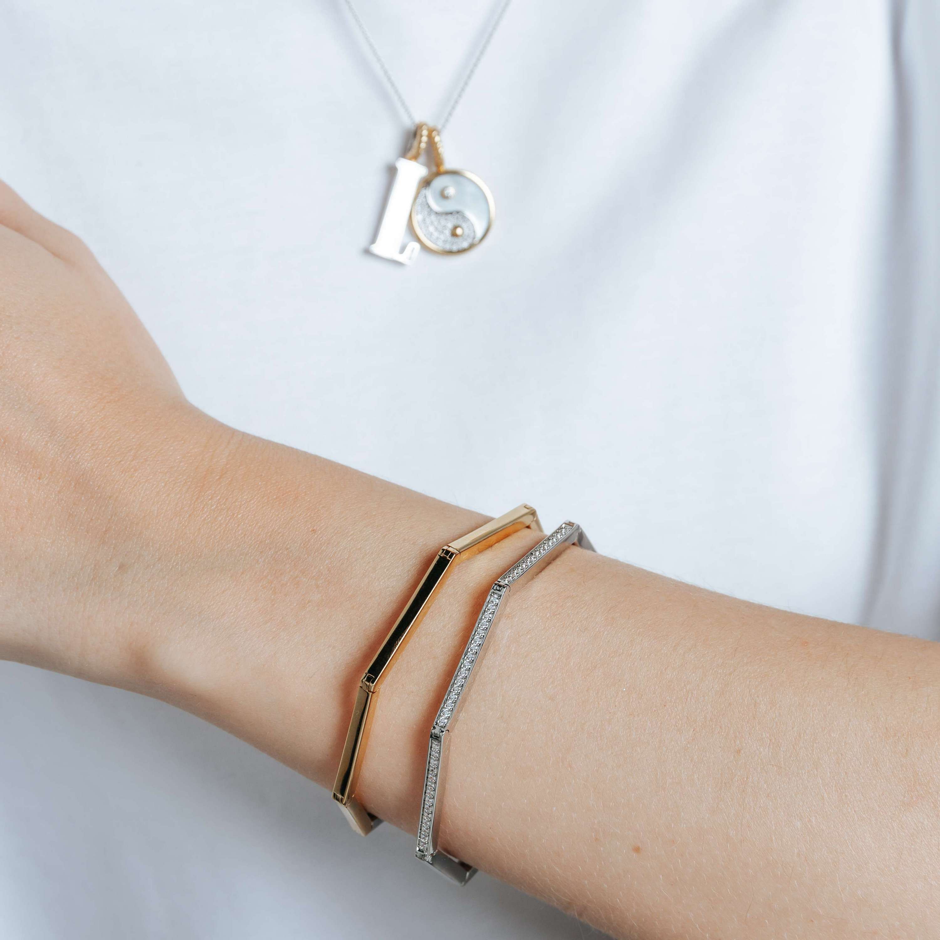 Voeg een vleugje moderne verfijning toe aan je dagelijkse look met de TI SENTO armband 23079SY, een elegante balans tussen design en luxe. Vervaardigd uit 925 sterling zilver en afgewerkt met warme geelgouden kleur, beschikt deze verfijnde armband over een opvallend geometrisch zeshoekig ontwerp. De wisselwerking tussen zachte rondingen en scherpe hoeken cre�ert een boeiend visueel effect, terwijl de warme plating een luxe warmte toevoegt. Deze bangle viert individualiteit en is een bewijs van de kracht van ingetogen elegantie. Draag de armband solo voor een minimalistische statement of combineer het met andere TI SENTO sieraden voor een samengestelde en verfijnde look. Vervaardigd met zorg voor de gevoelige huid, biedt deze nikkelvrije en hypoallergene armband langdurig comfort en kwaliteit.