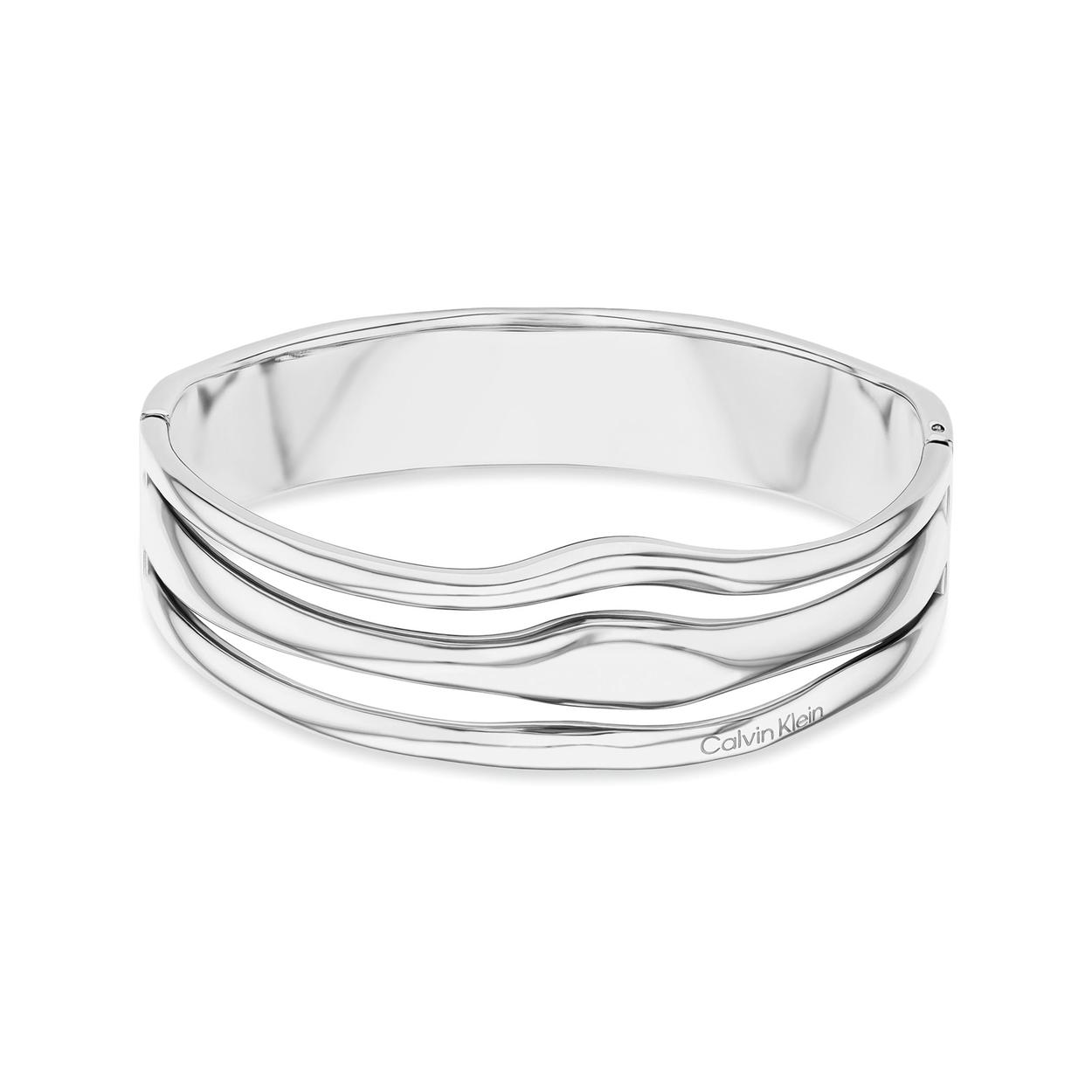 De Bangle armband  zilver kleurig  Wavy is een elegante toevoeging aan je sieradencollectie. Gemaakt van roestvrij staal en afgewerkt in een zilverkleur, straalt deze armband tijdloze klasse uit. Draag hem solo voor een subtiele uitstraling of combineer met andere armbanden voor een gedurfde look. Perfect voor elke gelegenheid!
