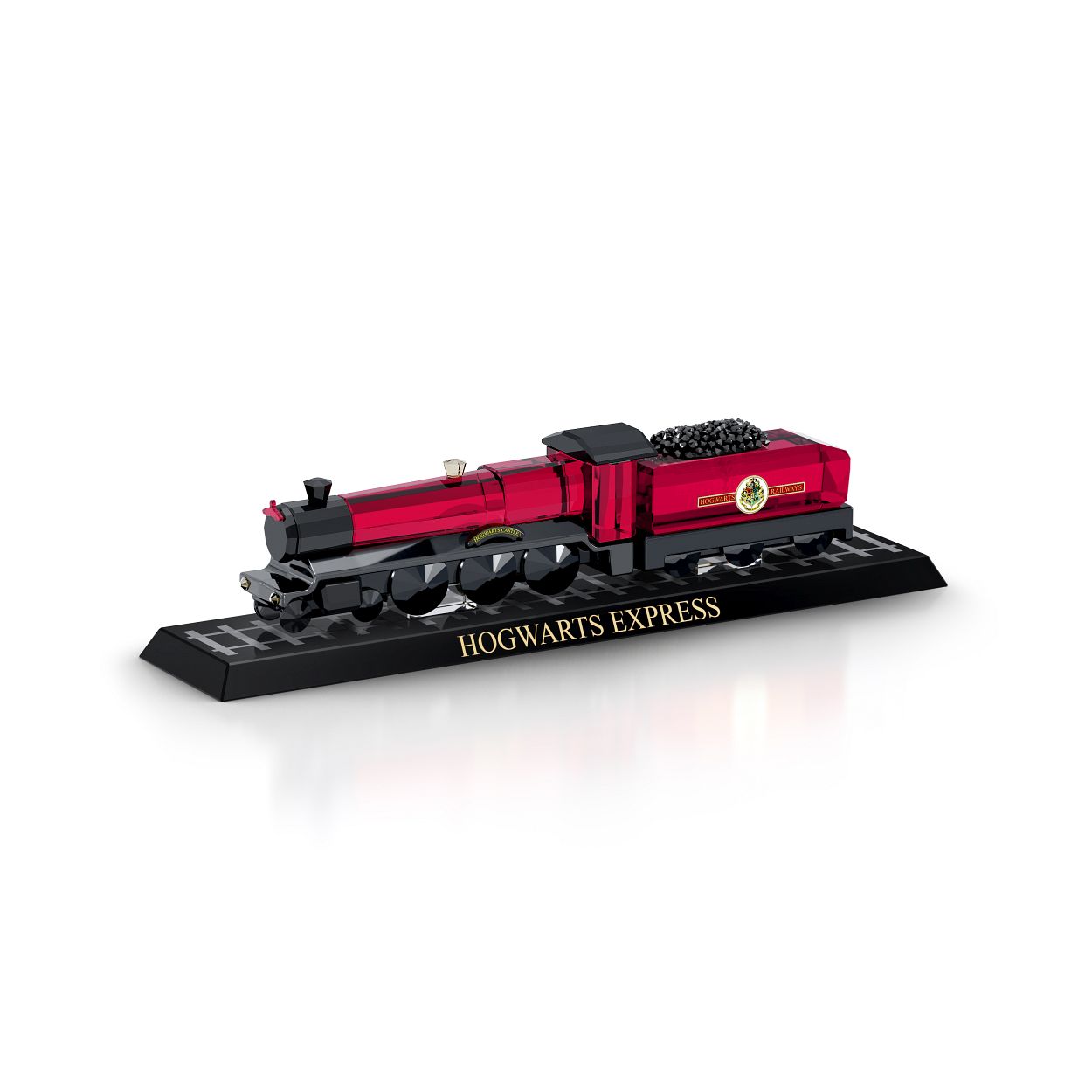 Deze gedetailleerde uitbeelding van de Zweinsteinexpres mag in geen enkele collectie van Harry Potter-fans ontbreken. De roodzwarte stoomtrein, die leerlingen van en naar Zweinsteins Hogeschool voor Hekserij en Hocus-Pocus vervoert, schittert dankzij de 790 vakkundig geslepen facetten. Op de zwarte glazen basis staan treinrails en deze is voorzien van 'Hogwarts Express' in gouden letters. Achter de stroomtrein zit bovendien ook een glinsterende kolenwagon. Een magisch geschenk afkomstig uit de wonderlijke wereld van hocus-pocus. Decoratieobject. Geen speelgoed. Niet geschikt voor kinderen jonger dan 15 jaar.