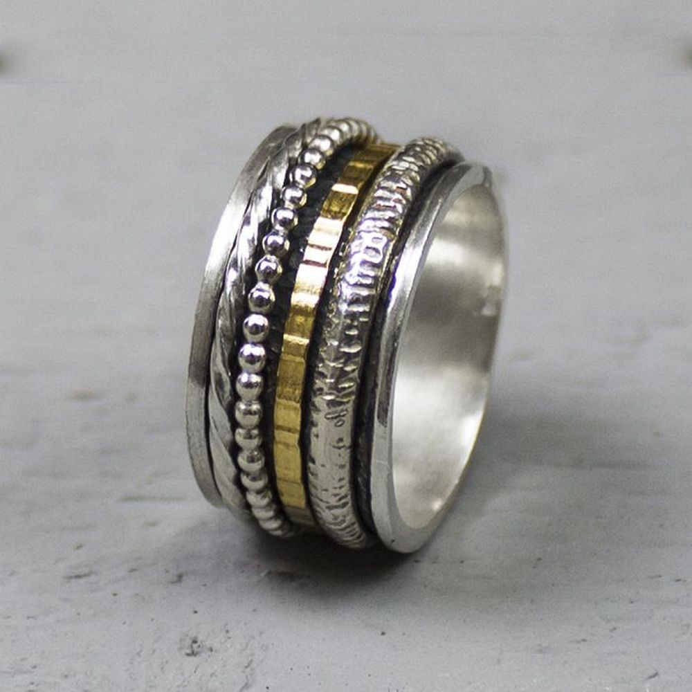 Bijzondere ring gemaakt van (geoxideerd) 925 sterling zilver en gold filled. De ringen in het midden van de ring kunnen bewegen, dit zorgt voor een speels effect. Onder de ring is gebruik gemaakt van geoxideerd zilver. 
