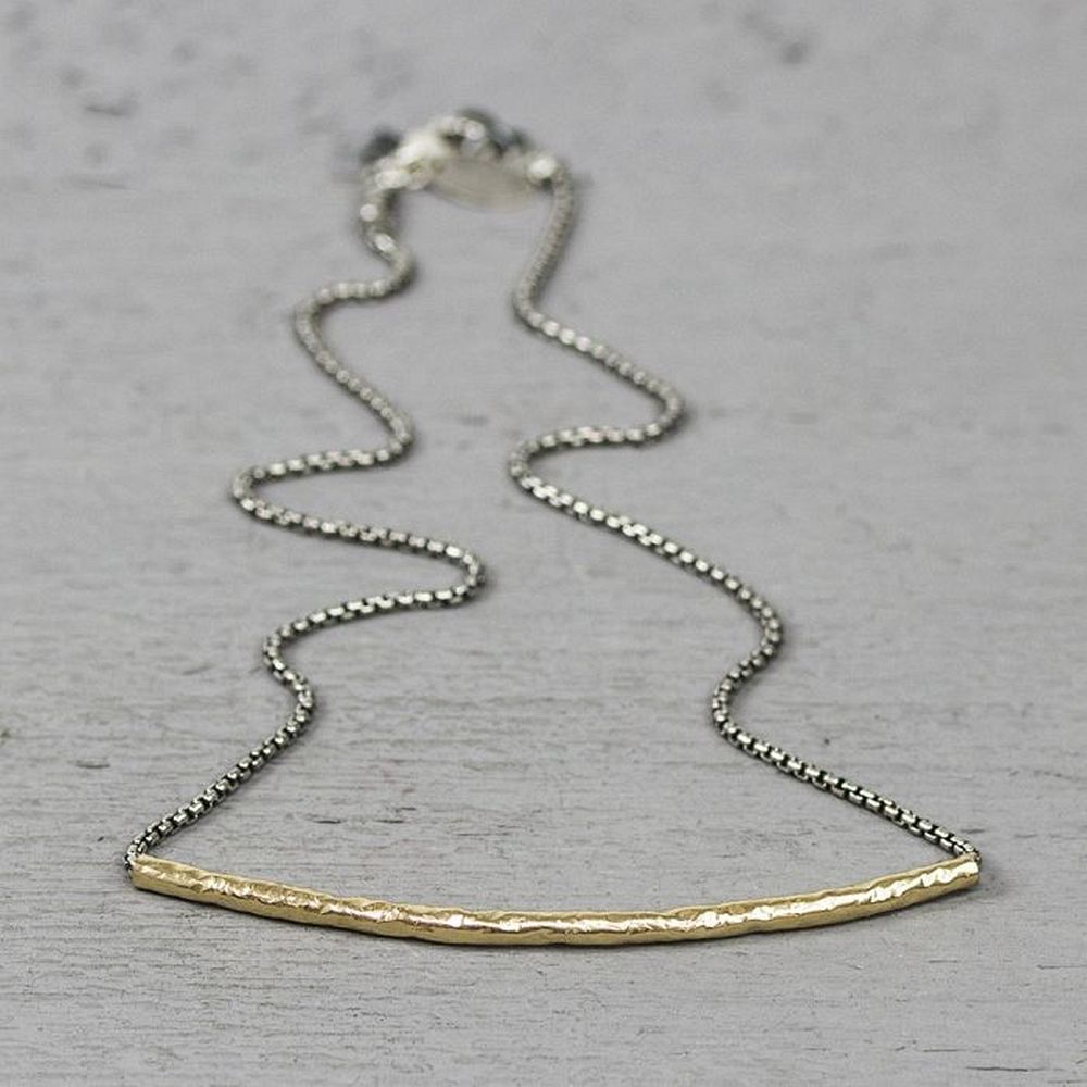 Collier gemaakt van 925 sterling geoxideerd zilver met daaraan een rond lopende buis van goldfilled. Mooi door z'n eenvoud! De lengte is 41cm.
