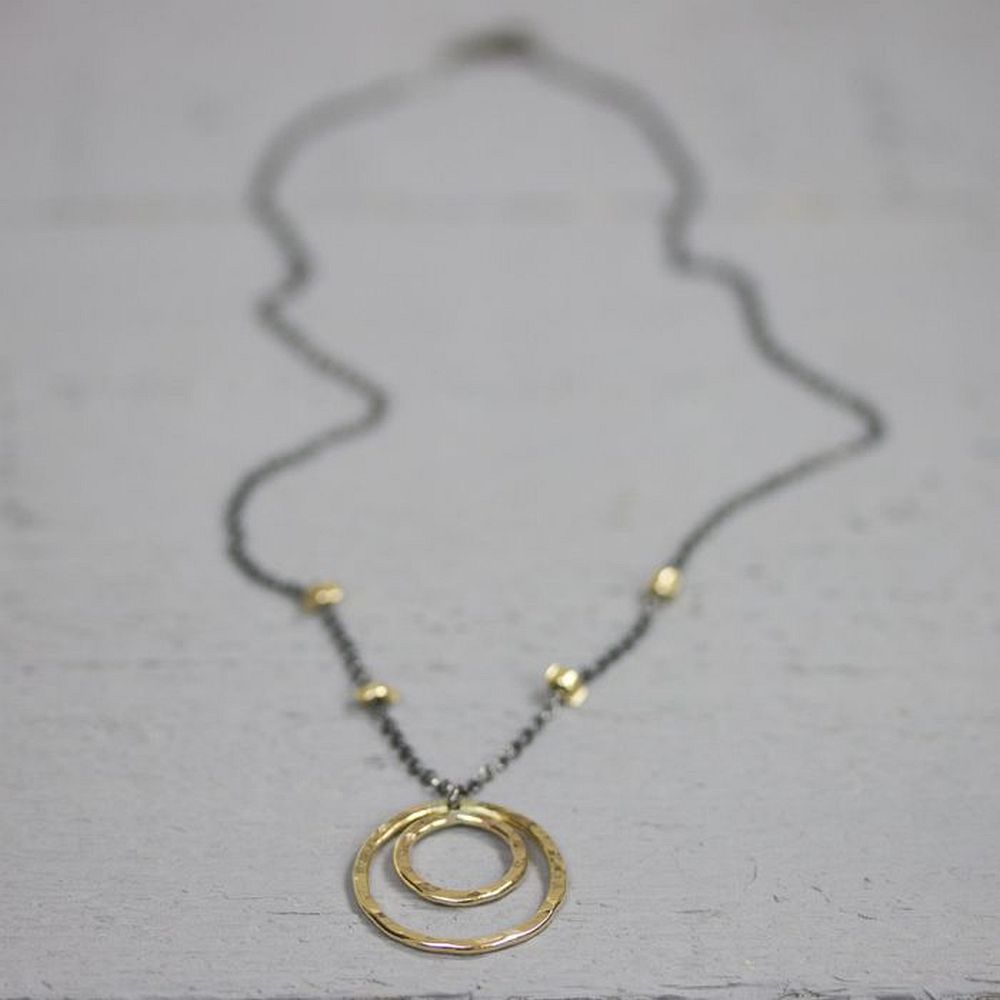 Collier gemaakt van 925 sterling zilver en geoxideerd zilver met een ronde hanger gemaakt van goldfilled. De lengte van het collier is 44cm.