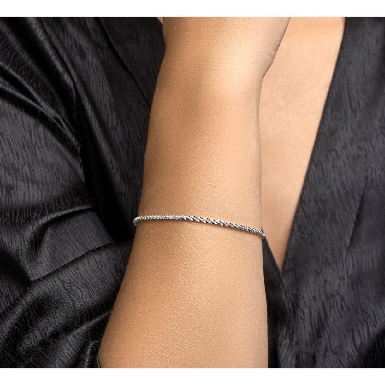 De armband is gemaakt van zilver en is zilverkleurig. Het is een sieraad voor dames.