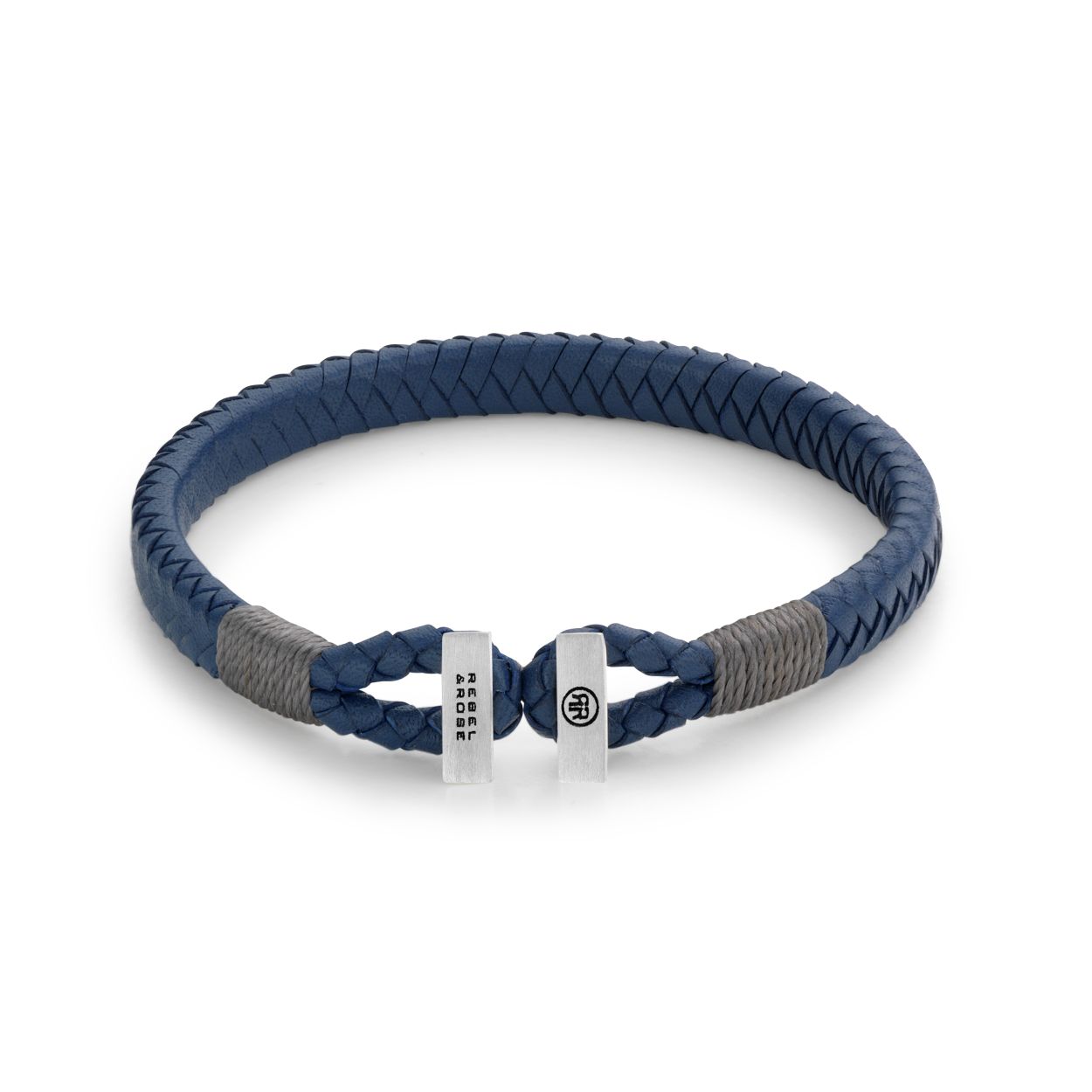 Blauwe met de hand gevlochten leren armband, aan de uiteinden afgewerkt met grijs draad. De sluiting is van 925 zilver en verbind de 2 uiteinden van de leren band. Daarom heet deze serie Connected in Leather. Het leer wordt soepeler met dragen en dus ook de uiteinden waarmee je de band aan elkaar vast maakt. Deze Rebel & Rose armband laat zich makkelijk combineren met andere zilveren, leren of kralenarmbanden.