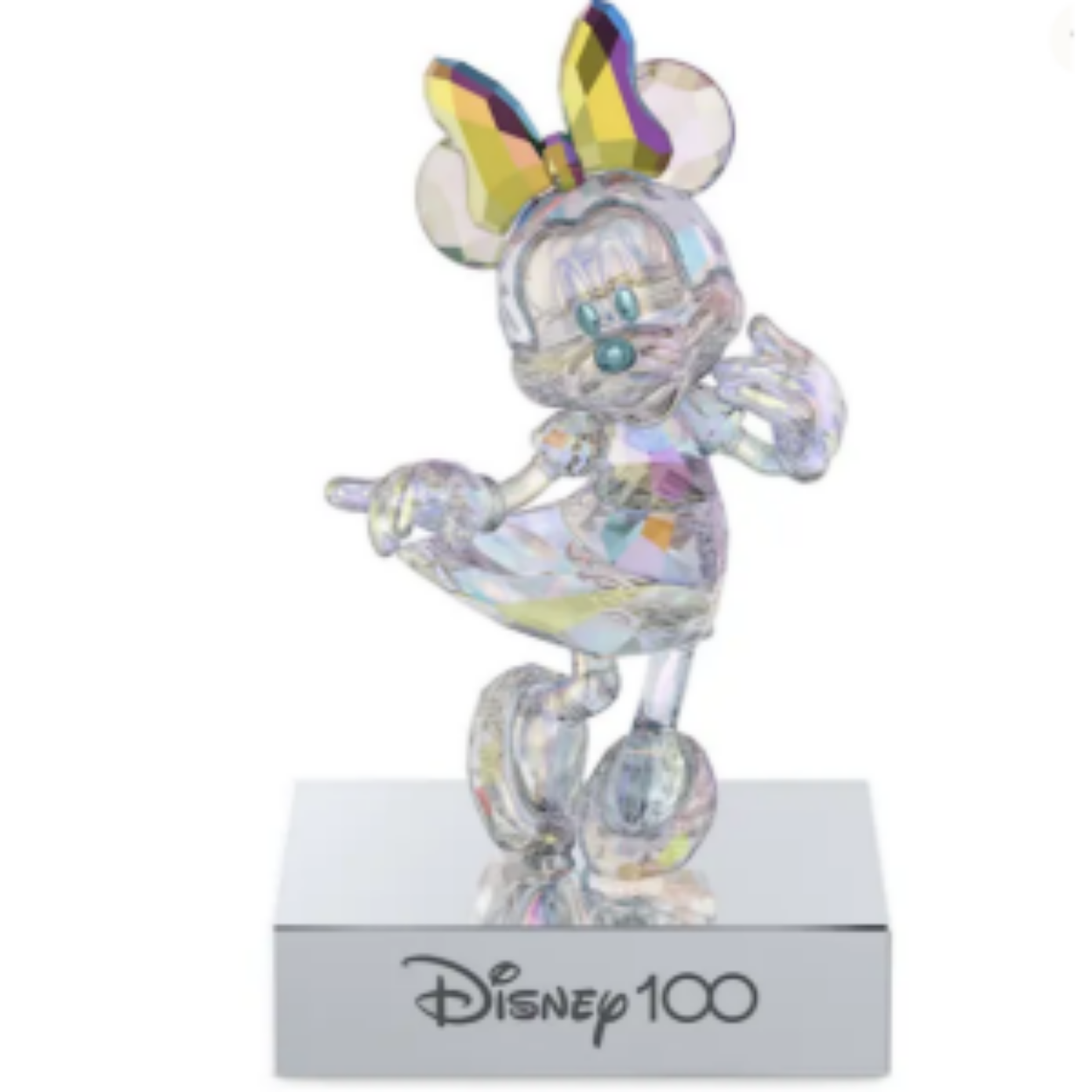 Dit vrolijke figuurtje ter ere van Disney100 is geïnspireerd op Minnie Mouse en geeft op prachtige wijze blijk van de savoir-faire van Swarovski. Minnie heeft een speelse buigende pose, 638 facetten en een reflecterende platinum look met een volledige coating van ons kenmerkende Aurora Borealis-effect voor een ultieme schittering en intensiteit. De metalen standaard heeft een verchroomde afwerking, zwart fluweel aan de onderkant en 'Disney100' gegraveerd aan de voorkant. U kunt het figuurtje losmaken van de standaard en neerzetten waar u maar wilt. Een speels object met een van de meest geliefde animatiefiguren ter wereld.