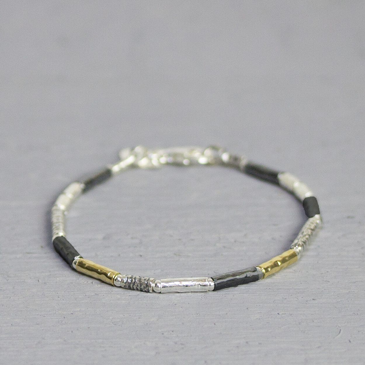 Armband uit de Touch of Gold-collectie van Jeh Jewels, gemaakt van 925 sterling zilver, geoxideerd zilver en gold filled. Geoxideerd zilver vervaagd na verloop van tijd. Combineer deze armband met het bijpassende collier. De glans van 925 sterling zilver maakt het een gewild edelmetaal voor de vervaardiging van sieraden. Het bestaat uit 92,5% puur zilver en 7,5% koper. Puur zilver is een zacht en buigzaam materiaal, het koper in 925 sterling zilver zorgt voor de stevigheid. De sieraden van Jeh Jewels zijn nikkel vrij. Gold filled komt uit Amerika en wordt daar al langer gebruikt voor de vervaardiging van sieraden met een "touch of gold" voor een betaalbare prijs. Het gold filled blijft op kleur, is slijtvast en de goudlaag is dik genoeg om lang te kunnen genieten van de warme uitstraling van goud. Gold filled wordt veelal ook goed verdragen door mensen die allergisch zijn voor andere metalen dan goud.