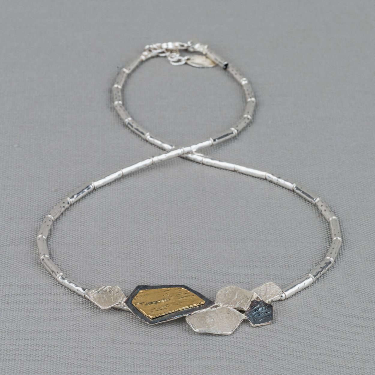 Collier gemaakt van 925 sterling zilveren buisjes in combinatie met een hanger van geoxideerd zilver en verguld. Combineer dit mooie collier met een paar oorsieraden, een armband en ring voor een complete look!