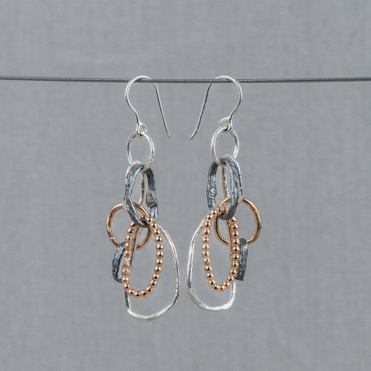 Oorhangers gemaakt van 925 sterling zilver, geoxideerd zilver en Goldfilled. Er zitten verschillende vormen ringetjes aan deze oorbellen, wat hem erg speels en uniek maakt! Combineer met een mooi collier en ring voor een complete look.
