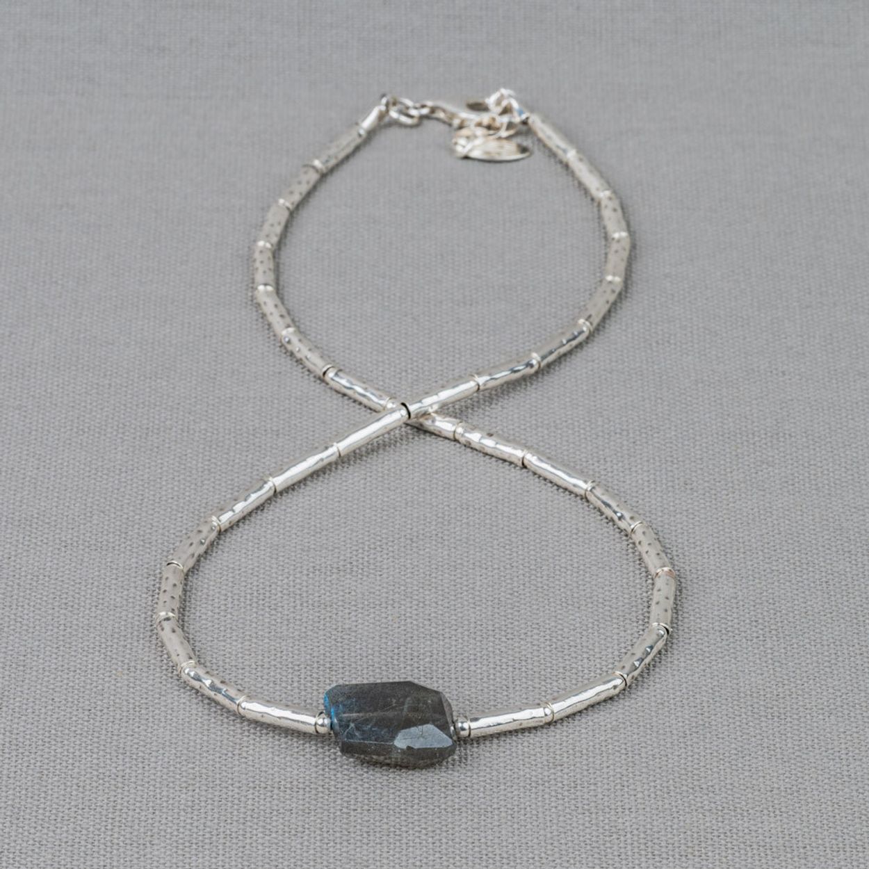 Collier gemaakt van 925 sterling zilveren buisjes in combinatie met de edelsteen Labradoriet. Labradoriet is een magische, beschermende en spirituele steen. Het beschermt het eigen energieveld (aura) tegen negatieve invloeden uit de omgeving. Wanneer je de steen beweegt/draait, komen de kleuren van de regenboog tevoorschijn. Combineer met de andere sieraden van Jeh Jewels.