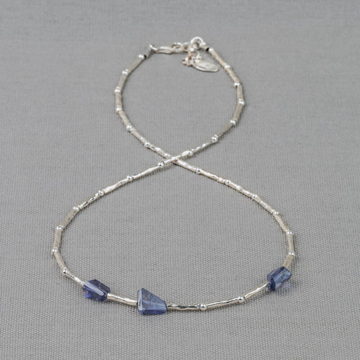 Collier gemaakt van 925 sterling zilveren buisjes in combinatie met de edelsteen Ioliet. Ioliet is een visionaire steen. De rustige kleuren werken als een vriendelijke gids om je spirituele visie te versterken. Deze edelsteen helpt je je persoonlijke bewustzijn te vergroten. Combineer dit collier met een paar oorbellen, een ring en armband voor een complete look!
