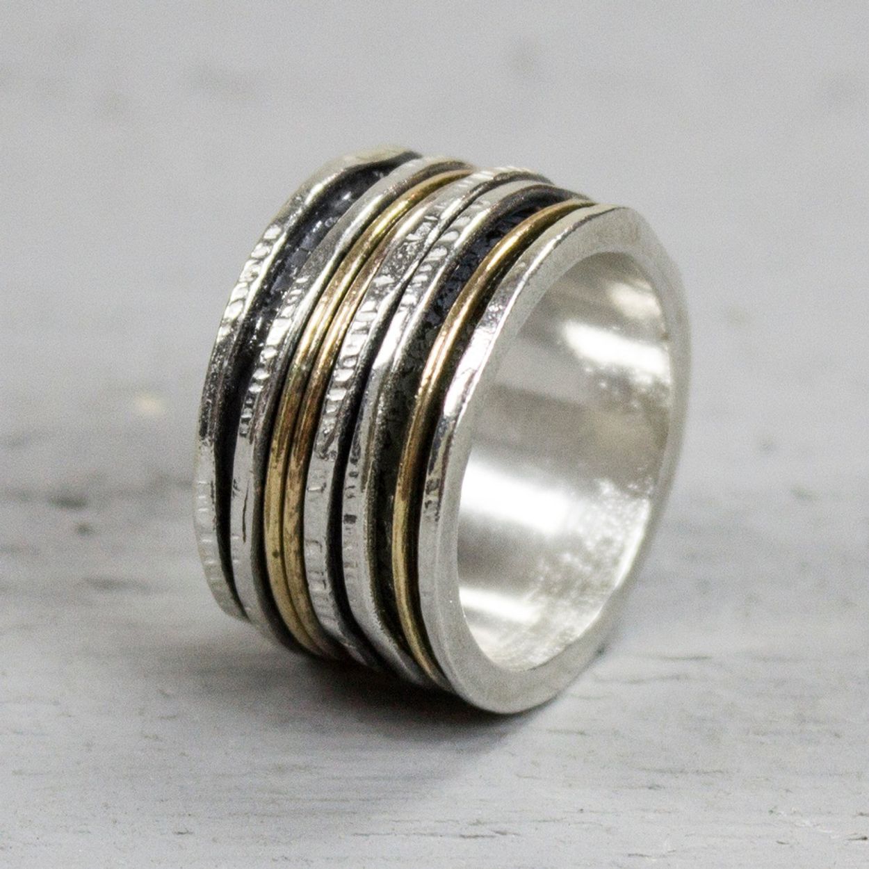 Bijzondere ring gemaakt van (geoxideerd) 925 sterling zilver en gold filled. De ringen in het midden van de ring kunnen bewegen, dit zorgt voor een speels effect. Onder de ring is gebruik gemaakt van geoxideerd zilver. Doordat de ringen speels bewegen, is het mogelijk dat de geoxideerde laag na verloop van tijd vervaagd. Productinformatie: De ring is gemaakt van 925 sterling zilver en het andere materiaal, gold filled, komt uit Amerika en wordt daar al langer gebruikt voor de vervaardiging van sieraden met een "touch of gold" voor een betaalbare prijs. Het gold filled blijft op kleur, is slijtvast en de 14karaats goudlaag is dik genoeg om lang te kunnen genieten van de warme uitstraling van goud. Gold filled wordt veelal ook goed verdragen door mensen die allergisch zijn voor andere metalen dan goud. De glans van 925 sterling zilver maakt het een gewild edelmetaal voor de vervaardiging van sieraden. Het bestaat uit 92,5% puur zilver en 7,5% koper. Puur zilver is een zacht en buigzaam materiaal, het koper in 925 sterling zilver zorgt voor de stevigheid. De sieraden van Jeh Jewels zijn nikkel vrij. Gold filled komt uit Amerika en wordt daar al langer gebruikt voor de vervaardiging van sieraden met een "touch of gold" voor een betaalbare prijs. Het gold filled blijft op kleur, is slijtvast en de 14karaats goudlaag is dik genoeg om lang te kunnen genieten van de warme uitstraling van goud. Gold filled wordt veelal ook goed verdragen door mensen die allergisch zijn voor andere metalen dan goud.