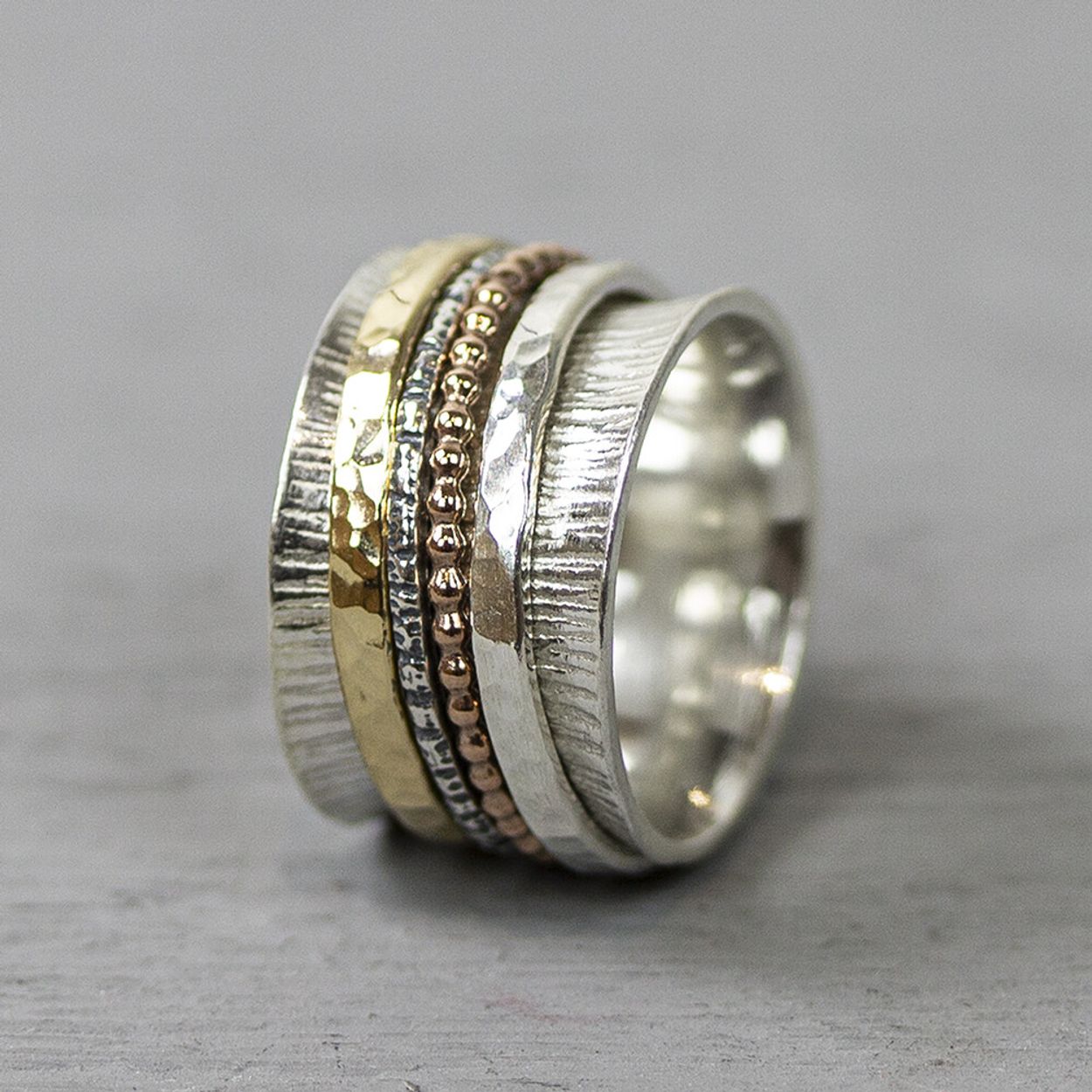 Ring gemaakt van 925 sterling zilver met draaiende bandjes. Deze bandjes zijn gemaakt van geoxideerd zilver, Goldfilled en rose. Combineer met andere sieraden van Jéh Jewels voor een complete look!