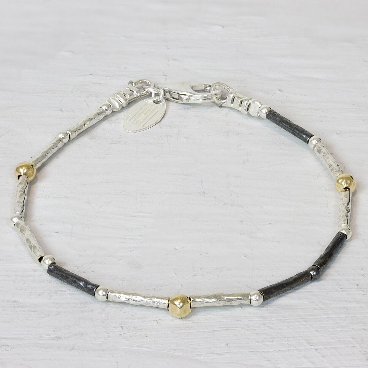 Armband van de najaarscollectie 2022 van Jeh Jewels gemaakt met buisjes van zilver en geoxideerd zilver met daartussen goldfilled balletjes. Ideaal om te matchen met het bijpassende collier. De glans van 925 sterling zilver maakt het een gewild edelmetaal voor de vervaardiging van sieraden. Het bestaat uit 92,5% puur zilver en 7,5% koper. Puur zilver is een zacht en buigzaam materiaal, het koper in 925 sterling zilver zorgt voor de stevigheid. De sieraden van Jéh Jewels zijn nikkel vrij. Op dit sieraad is gebruik gemaakt van geoxideerd zilver, dit is een oppervlakte bewerking. Het is mogelijk dat de geoxideerde laag na verloop van tijd door slijtage gaat vervagen. Goldfilled komt uit Amerika en wordt daar al langer gebruikt voor de vervaardiging van sieraden met een "touch of gold" voor een betaalbare prijs. Het goldfilled blijft op kleur, is slijtvast en de goudlaag is dik genoeg om lang te kunnen genieten van de warme uitstraling van goud. Goldfilled wordt veelal ook goed verdragen door mensen die allergisch zijn voor andere metalen dan goud.