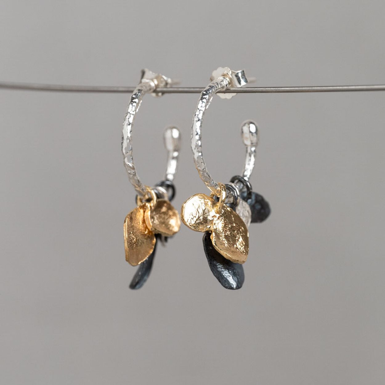 Oorhoepels gemaakt van 925 sterling zilver met daaraan losse hangertjes gemaakt van: 925 sterling zilver, geoxideerd zilver en verguld. Combineer deze oorbellen met het bijpassende collier voor een complete look!