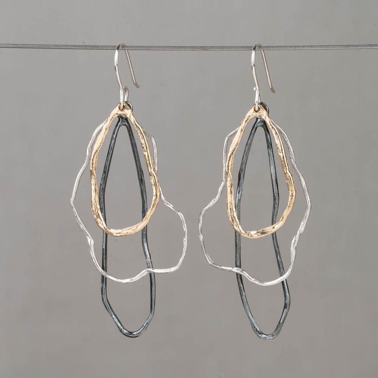 Oorhanger drie kleuren wolken trio is een speels en tegelijk verfijnd ontwerp waarin drie organische vormen sierlijk onder elkaar bewegen. De combinatie van 925 sterling zilver, geoxideerd zilver en zilver verguld zorgt voor een mooi kleurenspel. Het koele zilver, het donkere accent van het oxy en de warme vergulde vorm versterken elkaar op elegante wijze en geven de oorhangers diepte en karakter. Combineer met een mooi collier, een ring en armband voor een complete look!