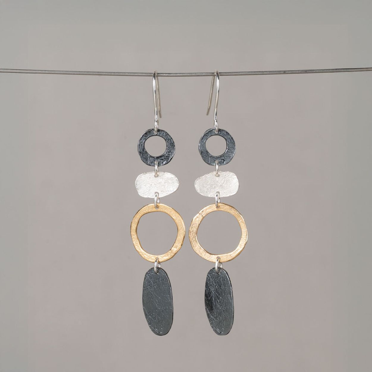 Oorhangers van 925 sterling zilver, geoxideerd zilver en verguld met organische vormen en open cirkels. Luchtig, speels en perfect te combineren met collier, ring en armband.