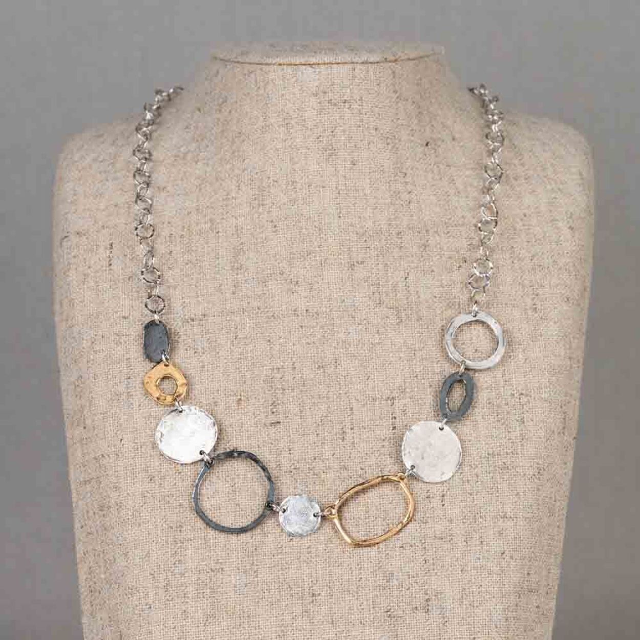 Dit collier is een mooie combinatie van organische vormen en subtiele contrasten. De verschillende schakels en cirkels vloeien speels in elkaar over. Dit collier valt prachtig om de hals. Vervaardigd van 925 sterling zilver, gecombineerd met geoxideerd zilver en verguld zilver, ontstaat een mooi kleurenspel. Het koele zilver, het donkere geoxideerde accent en de warme vergulde elementen versterken elkaar en geven het collier diepte en karakter. Combineer met een paar mooie oorbellen en een ring voor een complete look!