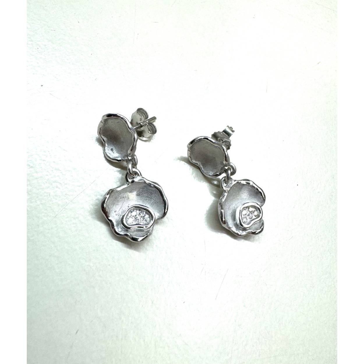 Handgemaakte oorbellen met zilver en zirkonium.
