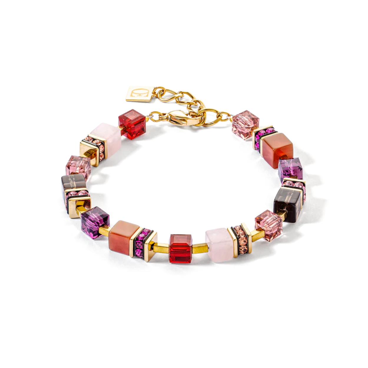 GeoCUBE® Precious statement armband goud-rood: stijlvolle glamour in rood De GeoCUBE® Precious statement armband in goud-rood valt op door zijn feestelijke elegantie en is de perfecte aanvulling op de bijpassende ketting. De kleinere GeoCUBES® van edelstenen en Swarovski-kristallen®, die zijn gebaseerd op de kleuren van de rode tint, geven de armband een subtiele maar opvallende uitstraling. Deze armband is ideaal voor speciale gelegenheden en zal ervoor zorgen dat je pols schittert met een stijlvolle, luxueuze glamour.