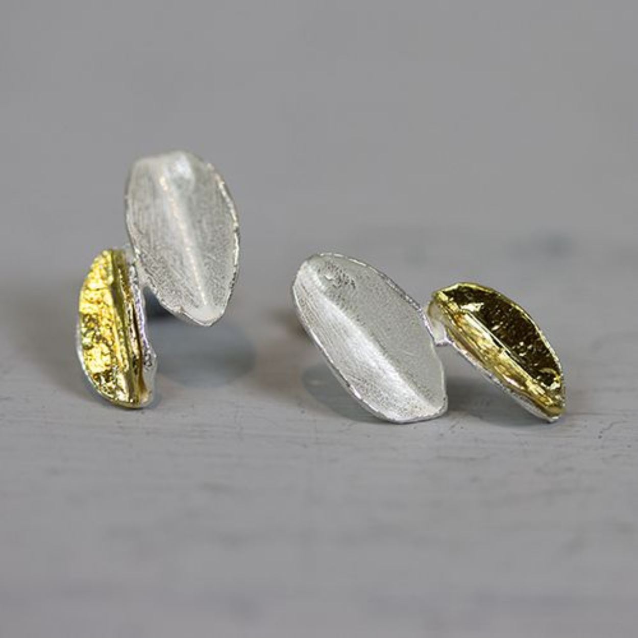 Oorbel gemaakt van 925 sterling zilver en verguld zilver in de vorm van twee bladeren.